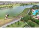 This aerial view shows a lake with a gazebo, golf course, walking path and a beautiful swimming pool for the neighborhood at 9459 Sw 52Nd Loop, Ocala, FL 34481