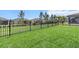 Well-maintained backyard featuring lush green grass and a sturdy black metal fence at 9459 Sw 52Nd Loop, Ocala, FL 34481