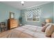 Comfortable bedroom featuring light blue walls, hardwood floors, and natural light at 9459 Sw 52Nd Loop, Ocala, FL 34481