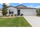 Charming home exterior featuring a well-manicured lawn and a two-car garage at 9459 Sw 52Nd Loop, Ocala, FL 34481