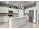 Bright, modern kitchen with white cabinetry, stainless steel appliances, and island with pendant lighting at 9459 Sw 52Nd Loop, Ocala, FL 34481