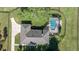 Aerial view of the home with a dark gray roof, screened pool, and lush green lawn at 9462 Sw 72Nd Ct, Ocala, FL 34476