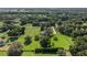 An aerial view showcasing a large, green estate with mature trees and well-maintained fencing at 9462 Sw 72Nd Ct, Ocala, FL 34476