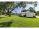 Lush backyard featuring mature trees, a well-maintained lawn, and a glimpse of the screened-in pool area at 9462 Sw 72Nd Ct, Ocala, FL 34476