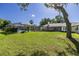 Spacious backyard with green grass, mature trees, and a screened-in pool enclosure at 9462 Sw 72Nd Ct, Ocala, FL 34476