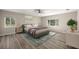 This bedroom features wood-look flooring, two windows, a ceiling fan, and stylish décor at 9462 Sw 72Nd Ct, Ocala, FL 34476