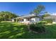 Exterior angle of the home features fresh paint, a manicured lawn, and mature landscaping at 9462 Sw 72Nd Ct, Ocala, FL 34476