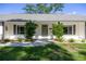 Traditional home featuring updated paint, front door decor, green grass, and tasteful landscaping at 9462 Sw 72Nd Ct, Ocala, FL 34476