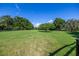 Expansive grassy field with mature trees, enclosed by a black fence on a sunny day at 9462 Sw 72Nd Ct, Ocala, FL 34476