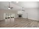 Bright living room with wood-look flooring, vaulted ceilings, and a classic brick fireplace at 9462 Sw 72Nd Ct, Ocala, FL 34476
