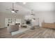 Open living room featuring a brick fireplace, wood flooring, and sliding door access at 9462 Sw 72Nd Ct, Ocala, FL 34476