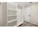 Bright walk-in closet with built-in white shelves and wood-look flooring at 9462 Sw 72Nd Ct, Ocala, FL 34476