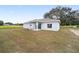 The back of a single-story home with a covered patio and a large backyard at 9731 Bahia Rd, Ocala, FL 34472