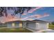 Charming single-story home with a two-car garage and a well-manicured lawn at sunset at 9731 Bahia Rd, Ocala, FL 34472