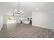 Open-concept living area with wood-look floors, leading to a modern kitchen and backyard access at 9731 Bahia Rd, Ocala, FL 34472