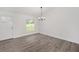 Bright living area showcasing wood-look floors, natural light, and a contemporary chandelier at 9731 Bahia Rd, Ocala, FL 34472
