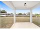 A covered patio with a view of the spacious backyard and a wooden fence at 9731 Bahia Rd, Ocala, FL 34472