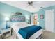 Light and airy bedroom with bright blue walls, ceiling fan and ensuite laundry room access at 9853 Se 175Th Pl, Summerfield, FL 34491