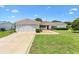 Charming single-story home with a well-maintained lawn, inviting curb appeal, and attached two car garage at 9853 Se 175Th Pl, Summerfield, FL 34491
