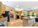 Spacious kitchen with wood cabinets, granite countertops, and an island overlooking the living area at 9853 Se 175Th Pl, Summerfield, FL 34491