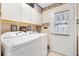Efficient laundry room with white washer, dryer and built in shelving at 9853 Se 175Th Pl, Summerfield, FL 34491