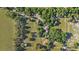 An aerial perspective of a large property showcasing a house, additional structures, and tree coverage throughout the land at 10528 Sw 27Th Ave, Ocala, FL 34476