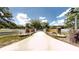 Long driveway leading to a gated home entrance with manicured landscaping and white fencing at 10528 Sw 27Th Ave, Ocala, FL 34476