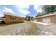 Tan single-story home with a three-car garage on a large, grassy lot and blue skies overhead at 10528 Sw 27Th Ave, Ocala, FL 34476