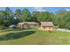 A house and detached garage are set on a well-maintained lawn, complete with a white picket fence in the background at 10528 Sw 27Th Ave, Ocala, FL 34476