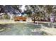 A single-story, tan home with a red awning and a three-car garage sits on a large, grassy lot at 10528 Sw 27Th Ave, Ocala, FL 34476