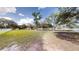 Expansive front yard featuring lush green grass, mature trees, and a charming white fence border at 10528 Sw 27Th Ave, Ocala, FL 34476