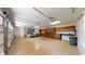 Spacious garage featuring ample storage cabinets and counter space, with a golf cart inside at 10528 Sw 27Th Ave, Ocala, FL 34476