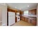 Functional kitchen featuring wooden cabinets, neutral countertops, and standard white appliances at 10528 Sw 27Th Ave, Ocala, FL 34476