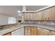 Bright kitchen features wood cabinets, granite countertops and view into an adjacent room with a fireplace at 10528 Sw 27Th Ave, Ocala, FL 34476