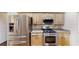 Kitchen showcasing stainless steel appliances, wood cabinets, granite countertops, and a gas range at 10528 Sw 27Th Ave, Ocala, FL 34476