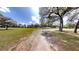 Expansive green lawn dotted with mature trees and a white fence under a bright, sunny sky at 10528 Sw 27Th Ave, Ocala, FL 34476