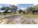 Landscaped lawn of a home that features a white fence, mature trees, and an American flag at 10528 Sw 27Th Ave, Ocala, FL 34476