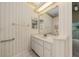 Well-lit bathroom featuring a large vanity, ample storage, and neutral-toned striped wallpaper at 11586 Sw 75Th Cir, Ocala, FL 34476