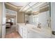 Bathroom featuring double sinks, large mirrors, and access to an adjacent bedroom at 11586 Sw 75Th Cir, Ocala, FL 34476