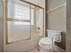 Cozy bathroom featuring a glass shower door, safety grab bar, and toilet at 11586 Sw 75Th Cir, Ocala, FL 34476
