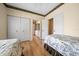 Bedroom showcasing two twin beds, hardwood floors, and access to an ensuite bathroom at 11586 Sw 75Th Cir, Ocala, FL 34476