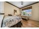 Comfortable bedroom featuring two twin beds, hardwood floors, and a window with a plaid valance at 11586 Sw 75Th Cir, Ocala, FL 34476