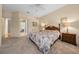 Cozy bedroom featuring a comfortable bed, carpet flooring, and natural light streaming through the windows at 11586 Sw 75Th Cir, Ocala, FL 34476