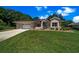 Lovely one-story home with manicured lawn, stone details, and an attached garage at 11586 Sw 75Th Cir, Ocala, FL 34476