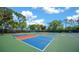 Multiple outdoor pickleball courts with colorful surfaces surrounded by trees at 11586 Sw 75Th Cir, Ocala, FL 34476