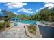 Community pool area, featuring mature trees and landscaping, with lounge chairs around it at 11586 Sw 75Th Cir, Ocala, FL 34476