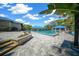 Community pool area with patio, landscaping, and buildings with blue rooftops under a blue sky at 11586 Sw 75Th Cir, Ocala, FL 34476