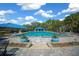 Community pool featuring pristine water, lounge seating, and lush landscaping under a clear blue sky at 11586 Sw 75Th Cir, Ocala, FL 34476