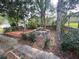 Outdoor seating area surrounded by mature trees and garden landscape at 1408 Torrey Pines Dr, Lady Lake, FL 32159