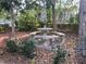 Beautiful backyard with a stone picnic table beneath an umbrella and lush greenery at 1408 Torrey Pines Dr, Lady Lake, FL 32159
